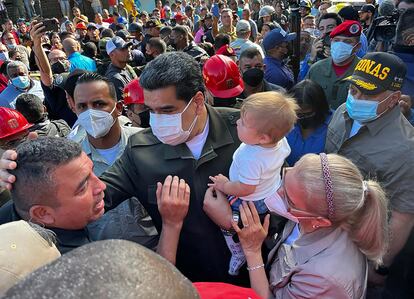 Nicolas Maduro (C) and his wife Cilia Flores (R) speaking with victims of a landslide while visiting the disaster area in Las Tejerias, Aragua state, Venezuela, on October 10, 2022.
