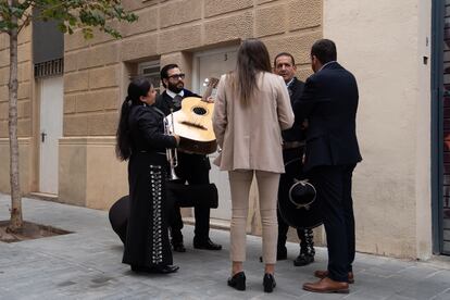 Una empleada de Junts habla con un trío de mariachis que había sido contratado para actuar frente de la sede del partido.