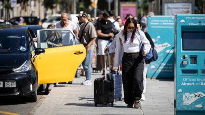 Turistas con maletas en la Plaza Cataluña de Barcelona.