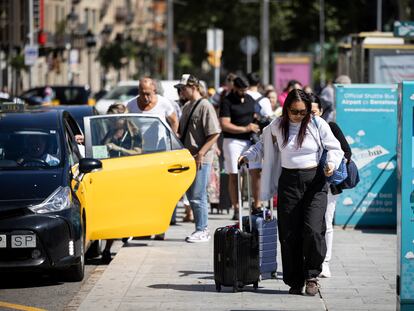 Turistas con maletas en la Plaza Cataluña de Barcelona.