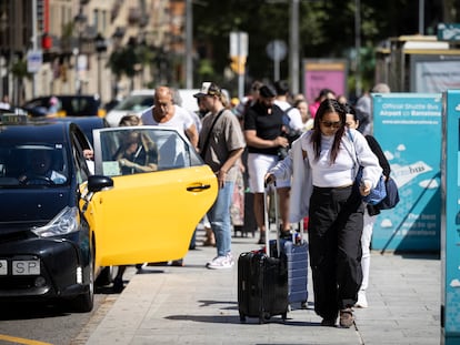 Turistas con maletas en la Plaza Cataluña de Barcelona.