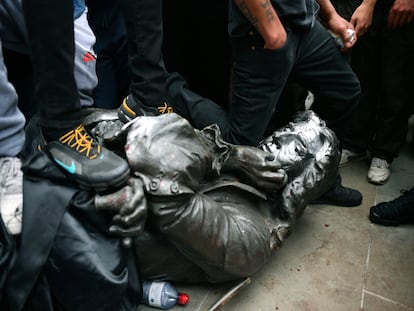 Un manifestante hinca su rodilla en el cuello de la estatua derribada de Edward Colston, este domingo en Bristol (Reino Unido).