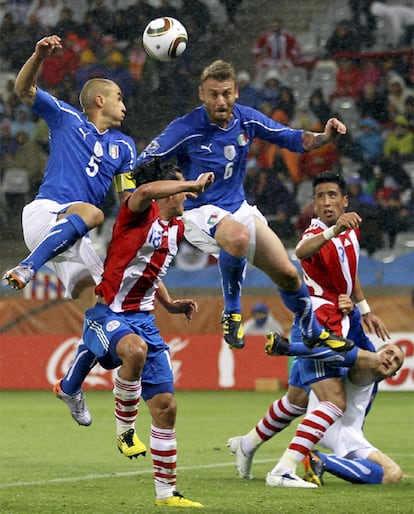 Los italianos Cannavaro, a la izquierda, y De Rossi, pugnan por un balón con el paraguayo Valdez.