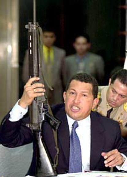 Chávez empuña un fusil durante una rueda de prensa.