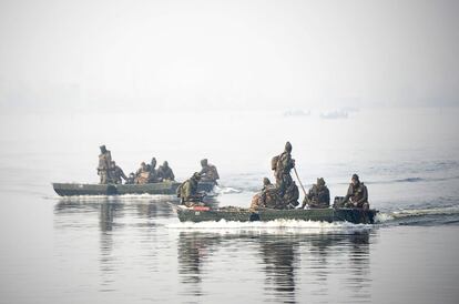 Los soldados del ejército indio recolectan malezas en el lago Dal, en Srinagar.