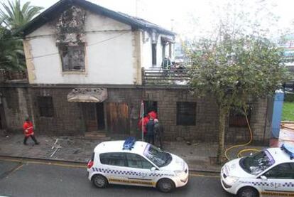 Bomberos y agentes de la policía local, en el restaurante incendiado.