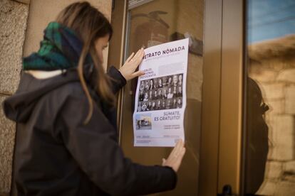 La fotógrafa Eli Garmendia mira el cartel pegado en la puerta del bar de Señuela (Soria) en el que se anunciaba la llegada de ella y de Carlos Pericás el fin de semana del 6 al 8 de mayo para retratar a los vecinos que quisieran. Señuela se suma así al proyecto Retrato nómada, un archivo con retratos de las personas de pueblos de menos de 500 habitantes.