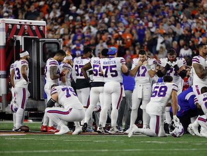 jugadores de los Buffalo Bills mientras su compañero Damar Hamlin es trasladado en ambulancia, este lunes.