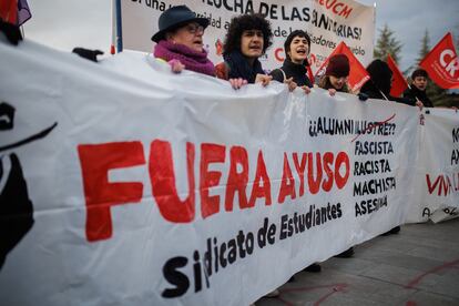 Varias personas con una pancarta en la que se lee: 'Fuera Ayuso' durante la concentración celebrada contra el nombramiento de Ayuso en la Complutense, este martes.