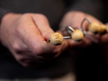 Una persona sujeta uno de los premios de las bolas de los bombos del Sorteo Extraordinario de Navidad, en el Teatro Real (Madrid).