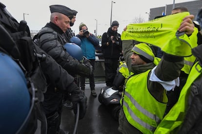 Un manifestante sostiene una pancarta con la inscripción "Revolución: policías corruptos" frente a policías antidisturbios durante la manifestación en Estrasburgo.