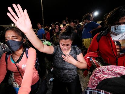 Dos mujeres hondureñas rezan antes de poner rumbo a Estados Unidos en una nueva caravana de migrantes que se formó en la noche del 9 de diciembre en San Pedro Sula.