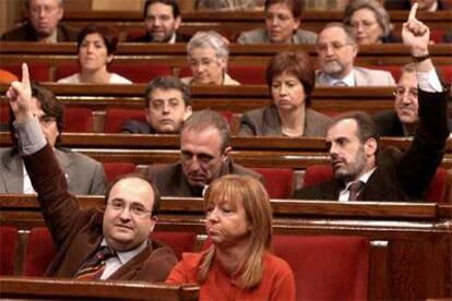 El portavoz del PSC, Miquel Iceta (abajo), y el diputado de ERC Joan Rigau dan instrucciones a los compañeros de sus grupos, durante la votación en el Parlamento de Cataluña.