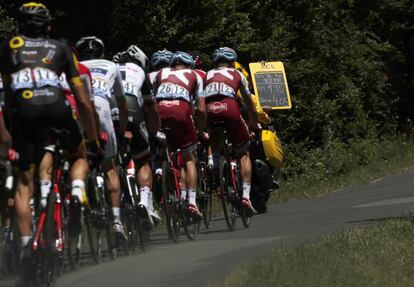 Un miembro de la organización del tour muestra a los corredores el tiempo entre ellos y la cabeza de carrera.