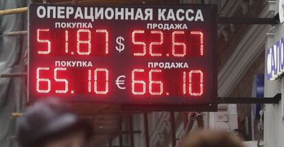 Dos mujeres pasan por delante de un panel que informa sobre el cambio de divisas en Mosc&uacute; (Rusia).