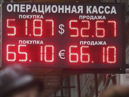 Dos mujeres pasan por delante de un panel que informa sobre el cambio de divisas en Mosc&uacute; (Rusia).