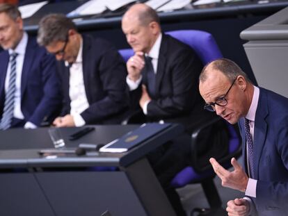 El líder de la oposición alemana, el conservador Friedrich Merz, durante su intervención este martes en el Bundestag, con el canciller Olaf Scholz y los ministros Robert Habeck (centro) y Christian Lindner escuchándole en sus escaños.