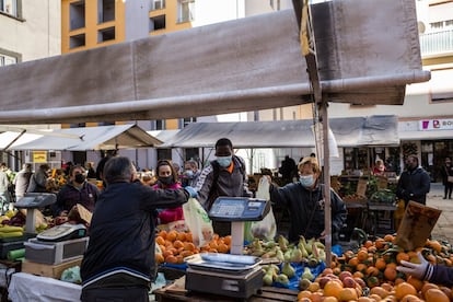 El mercado de Piazza Cavallotti, en el centro de Livorno. Los voluntarios de La Riuso compran aquí comida para la actividad gratuita de ayuda ambulante que se ofrece a los ancianos de la zona del distrito Garibaldi en el marco del proyecto Riconoscersi solidali (Reconocerse solidarios). En la imagen, Lansseny, maliense de 22 años que lleva tres viviendo en Italia, recoge una bolsa.