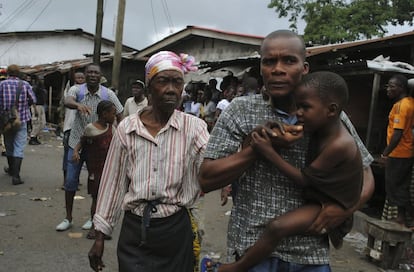 Los residentes del barrio de West Point en Monrovia (Liberia) tratan de escapar de la cuarentena que el Gobierno ha impuesto por el brote del ébola. Una multitud se ha rebelado contra las autoridades lanzando pìedras.