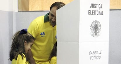 Un hombre vota acompa&ntilde;ado de su hija en Belo Horizonte