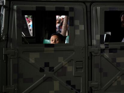 Un niño asoma la mirada por la ventana de un vehículo militar durante una exposición en el Ángel de la Independencia, este viernes.