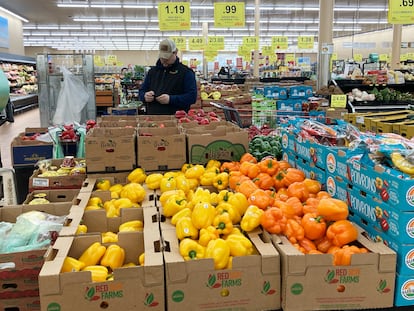 A man looks at his mobile phone while shopping at a grocery store in Buffalo Grove, Illinois, on March 19, 2023.