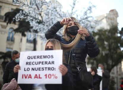 Una peluquera corta el pelo a una mujer durante una concentración frente al Congreso de los Diputados. Con el lema ‘SOS Peluquería y Estética’, este acto forma parte de las acciones llevadas a cabo por la alianza del sector para demandar la bajada del IVA al 10%,