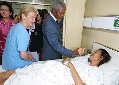 El secretario general de la ONU, Kofi Annan, y su esposa visitan a una enferma de sida en un hospital de Bangkok.