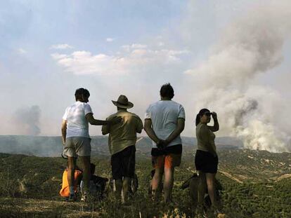 Un grupo de personas observa el incendio del campo de tiro de Cerro Muriano, el pasado 29 de julio.
