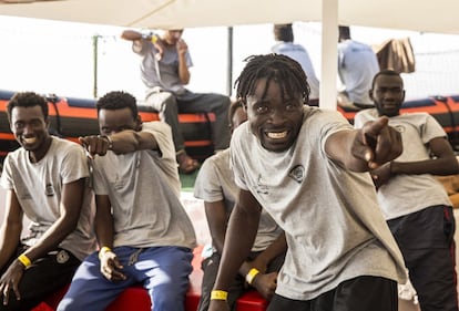 Inmigrantes a bordo del barco de ayuda Open Arms señalan los barcos que los acompañan cuando el barco se acerca al puerto de Barcelona, el 4 de julio de 2018.