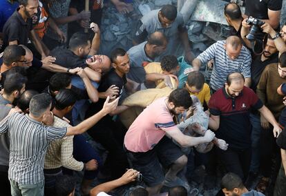 Un hombre lloraba este domingo en el campo de refugiados de Al Magazi, en Gaza, mientras un grupo de personas retiraba un cadáver de entre los escombros de un edificio destruido por un bombardeo.