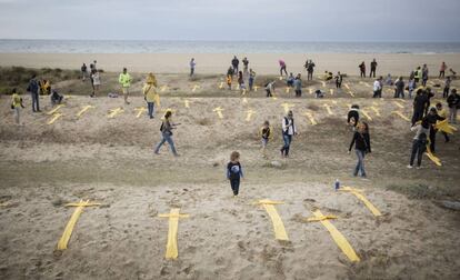 Creus grogues fetes amb tovalloles en solidaritat amb els polítics presos a la platja de Mataró, aquest diumenge.