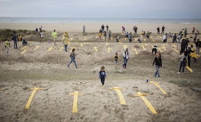 Puesta de cruces amarillas hechas con toallas en solidaridad con los políticos presos catalanes en la playa de Mataró, este domingo.