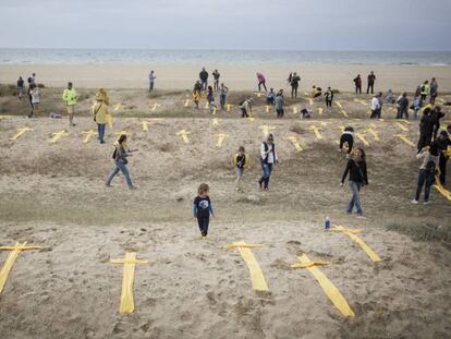 Puesta de cruces amarillas hechas con toallas en solidaridad con los políticos presos catalanes en la playa de Mataró, este domingo.