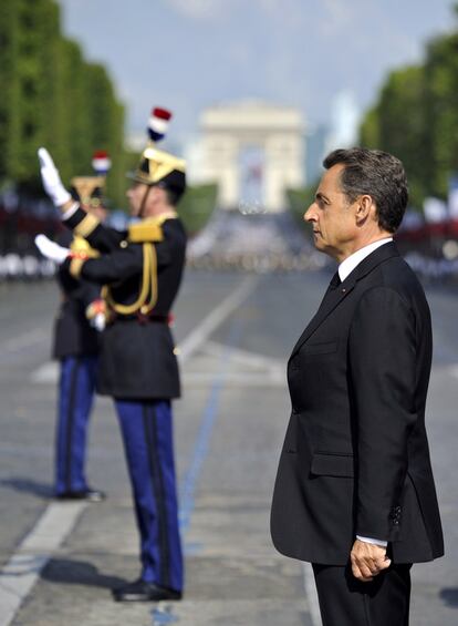 El presidente francés Nicolas Sarkozy escucha a la banda del Primer Regimiento de Infantería de los Guardias Republicanos, poco antes de iniciarse el desfile en los Campos Elíseos.