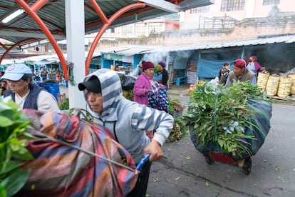 Cargadores ayudan a los clientes a transportar varios sacos cargados de plantas medicinales.

