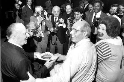 Foto tirada em 1984. O então presidente do McDonald's, Ed Rensi (centro), preparou para Richard McDonald (esquerda) o hambúrguer que levou a rede à marca de 50 milhões de sanduíches. O palhaço Ronald McDonald também participa da comemoração.