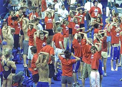 Los nadadores de Estados Unidos hacen estiramientos al borde de la piscina.