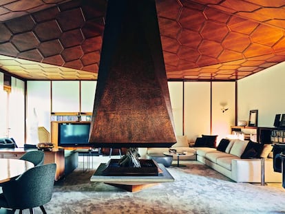 El salón como espectáculo: la chimenea es de cobre y el techo, de madera de nogal con forma de panel de miel. |