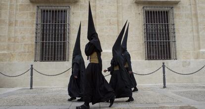 Nazarenos de la Hermandad de los Estudiantes abandonando este martes la Universidad de Sevilla tras la cancelación de su estación.