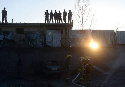 Bomberos afganos apagan un incendio tras un ataque terrorista en una oficina electoral, en Kabul.