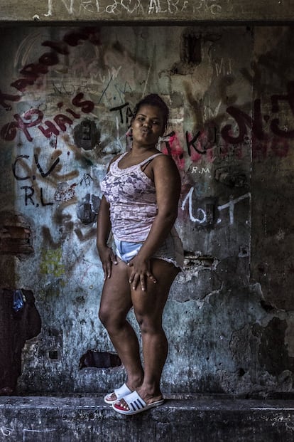 Mulher que vive na favela em frente ao vão de um elevador, atualmente coberto de grafites, no edifício abandonado do Instituto Brasileiro de Geografia e Estatística (IBGE). Favela da Mangueira, Rio de Janeiro. Cerca de 40% dos lares das favelas dependem economicamente das mulheres. Entre todas, calcula-se que anualmente ganhem em torno de 8,2 bilhões de dólares do total dos recursos que entram nessas comunidades.