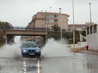 Un vehículo circula por una calle anegada en Torrevieja, Alicante, este sábado.