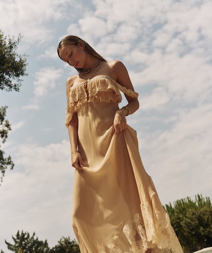 Ester Expósito lleva vestido nude con encaje, collares chunky en capas, pulsera y anillo dorados, todo de CHLOÉ.