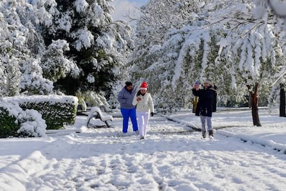 Un grupo de personas camina por un parque cubierto de nieve, en Monclova, estado de Coahuila (M&eacute;xico).