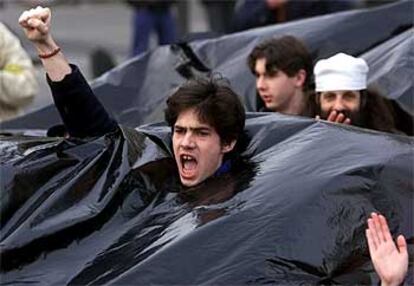 Manifestantes bajo un plástico, símbolo de la marea negra, en Nantes (Francia), en 2000.