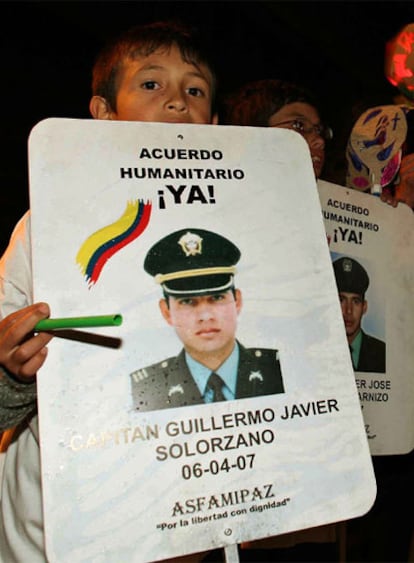 Un niño muestra en Bogotá la foto de su familiar secuestrado, en una manifestación para pedir la liberación de todos los rehenes tras el anuncio efectuado el domingo por las FARC.