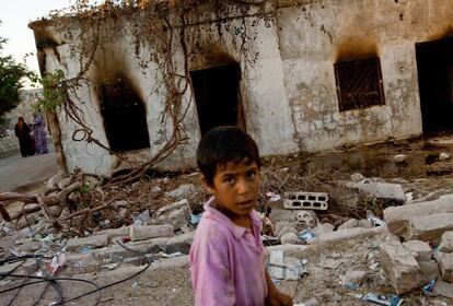 Un niño delante de una de las casas calcinadas tras el ataque.