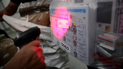 Un empleado del Tribunal Electoral escanea bolsas con papeletas electorales este sábado en Panamá.