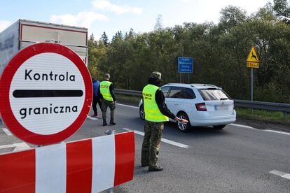 Agentes de la guardia fronteriza polaca controlan los vehículos en el puesto temporal de Chyzne, en la frontera polaca con Eslovenia, este miércoles. 